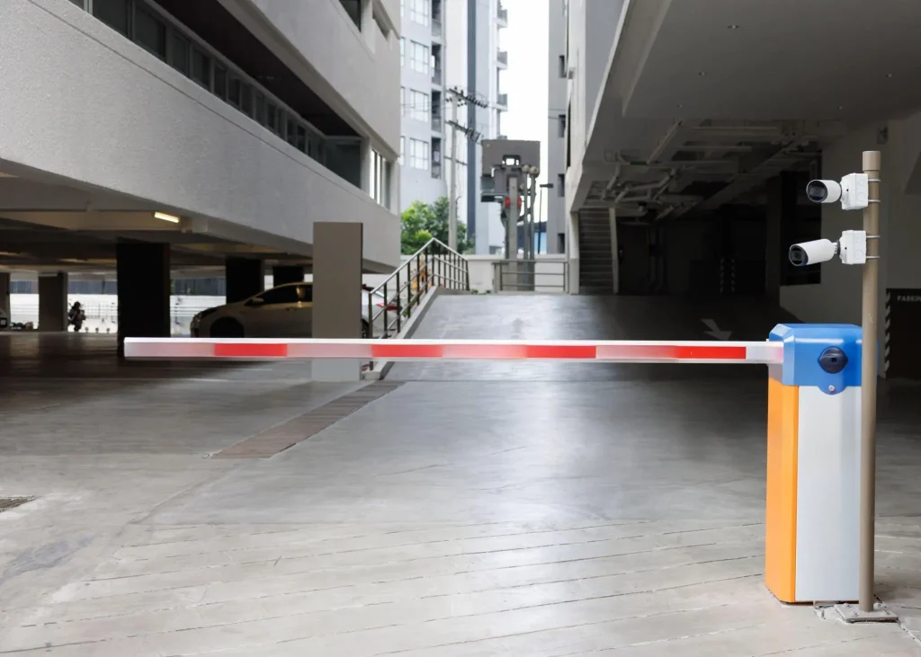 Boom barrier gate with mounted CCTV cameras at a commercial entry point in Qatar for added security.