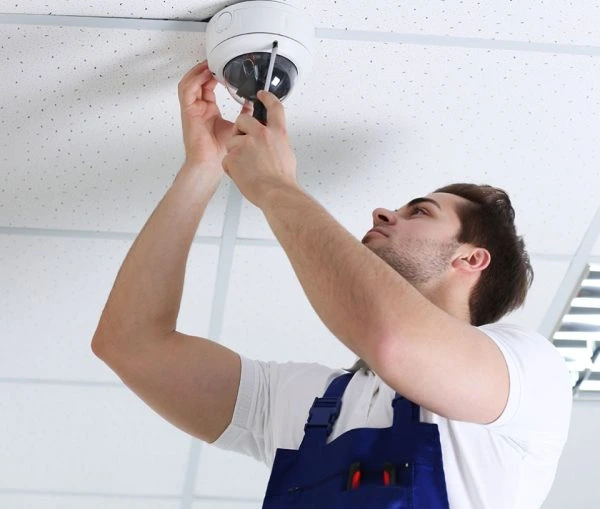 Certified CCTV consultant in Qatar mounting a camera as part of system approval process.