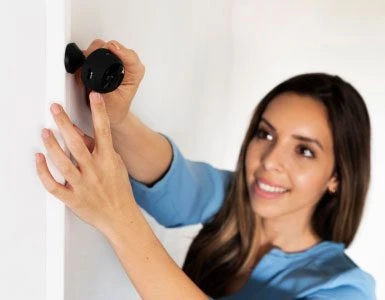 CCTV technician mounting a camera on an indoor wall during an MOI-approved installation.