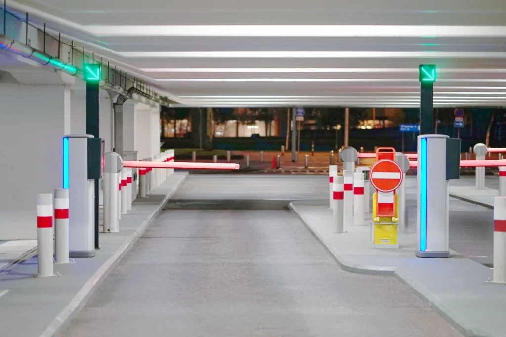 Multi-lane automated gate barrier system in Qatar inside a basement parking with entry indicators.