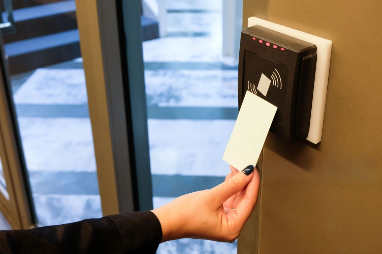 Person scanning RFID card on access control reader